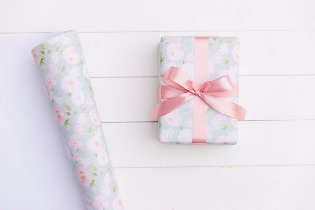 Floral-wrapped gift box with pink ribbon representing a thoughtful 1st anniversary gift idea