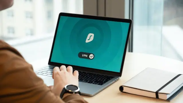 10:09Claude responded: A person using a laptop with a VPN application active on screen, displayed against a teal background with a shield icon.A person using a laptop with a VPN application active on screen, displayed against a teal background with a shield icon.